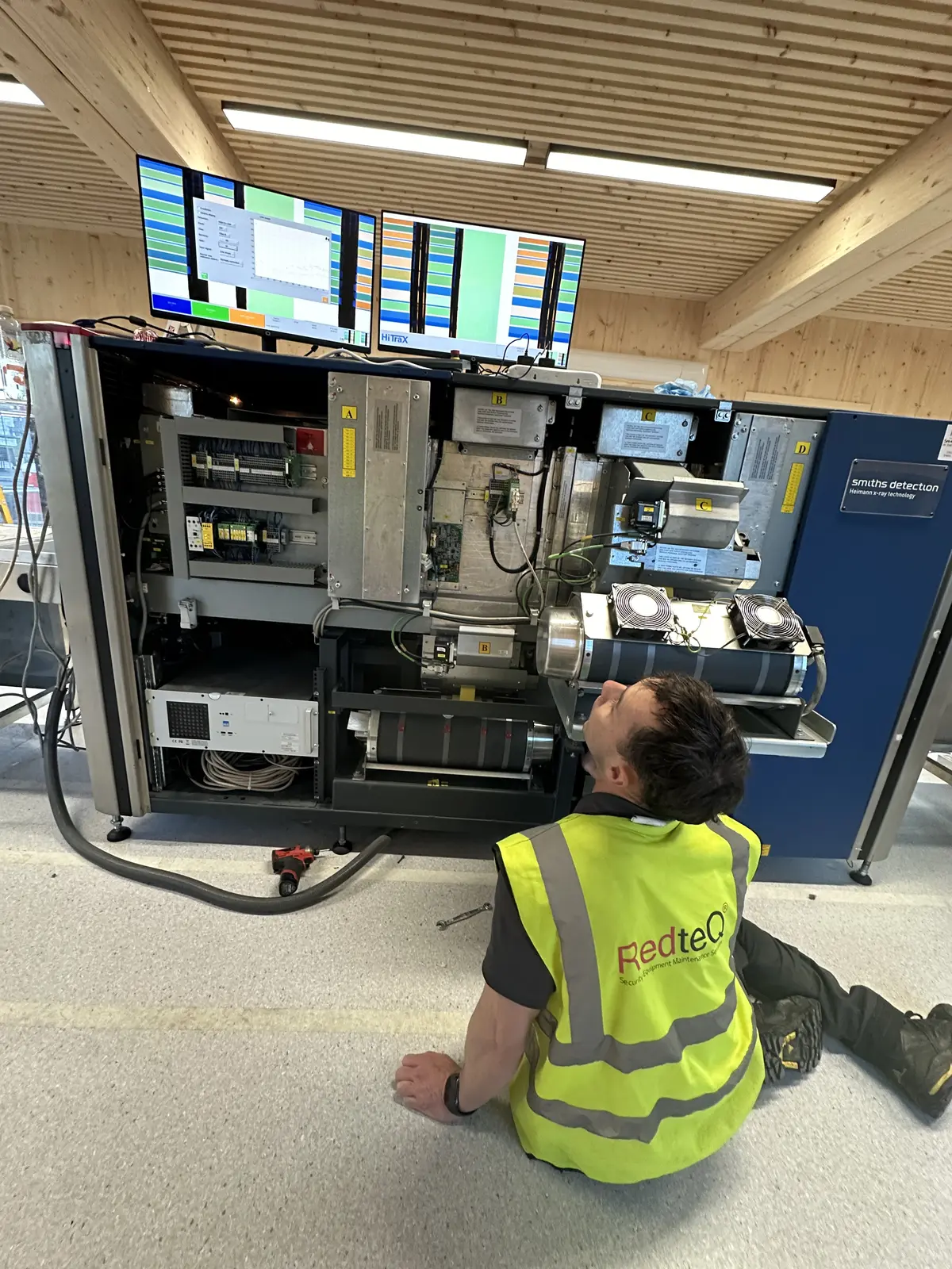 RedteQ engineer diagnosing an open X-ray machine during a service visit