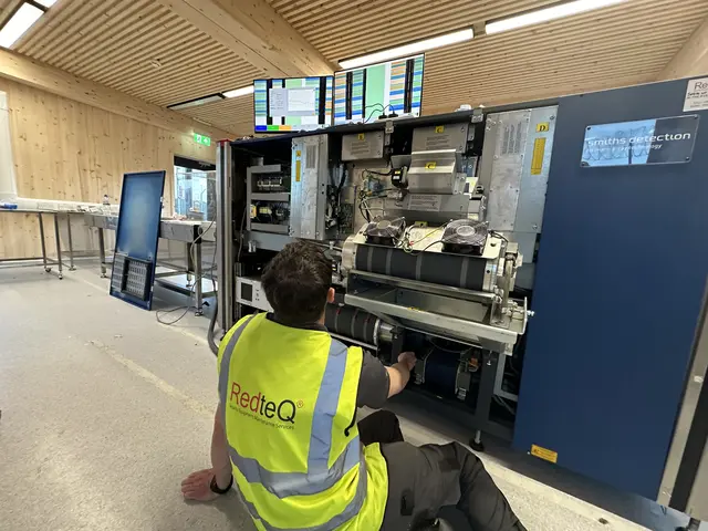 RedteQ engineer in branded vest servicing screening equipment