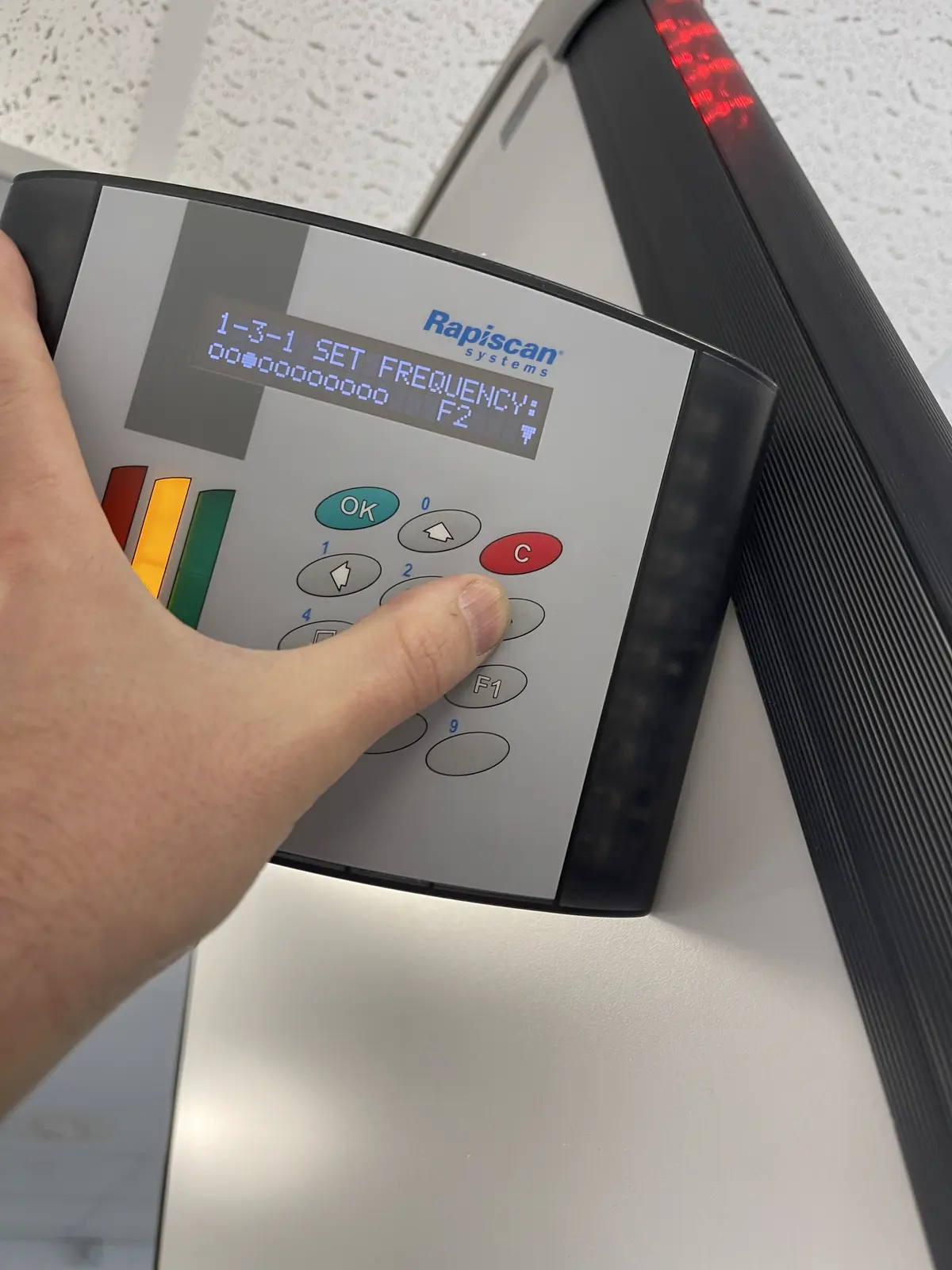 Handheld metal detector screening alongside a walk-through metal detector